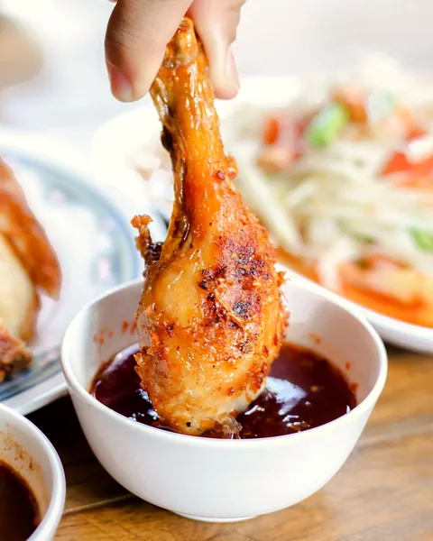 Tangan mencocol paha ayam ke mangkuk sambal kecap (foto ilustrasi)